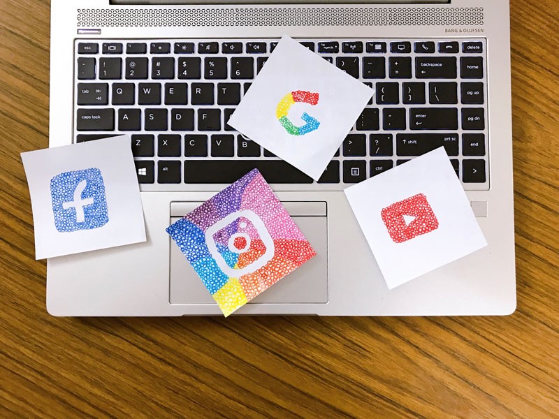 social media logo drawings on top of a laptop keyboard
